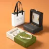 Custom rigid paper earring box with handle, showing branding, foam insert, and premium packaging design for jewelry retailers
