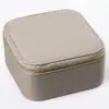 Custom leather travel jewelry box open with velvet-lined pouches, ring rolls and earring pads, embossed logo on lid