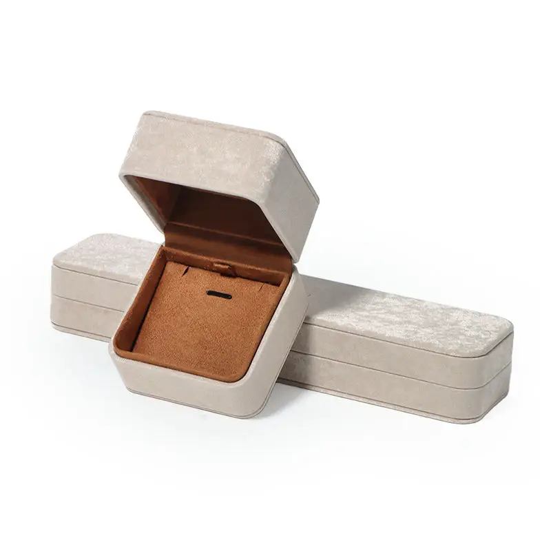 Interior view of gray leatherette flip-top jewelry box showing velvet lining and foam ring insert for brand packaging