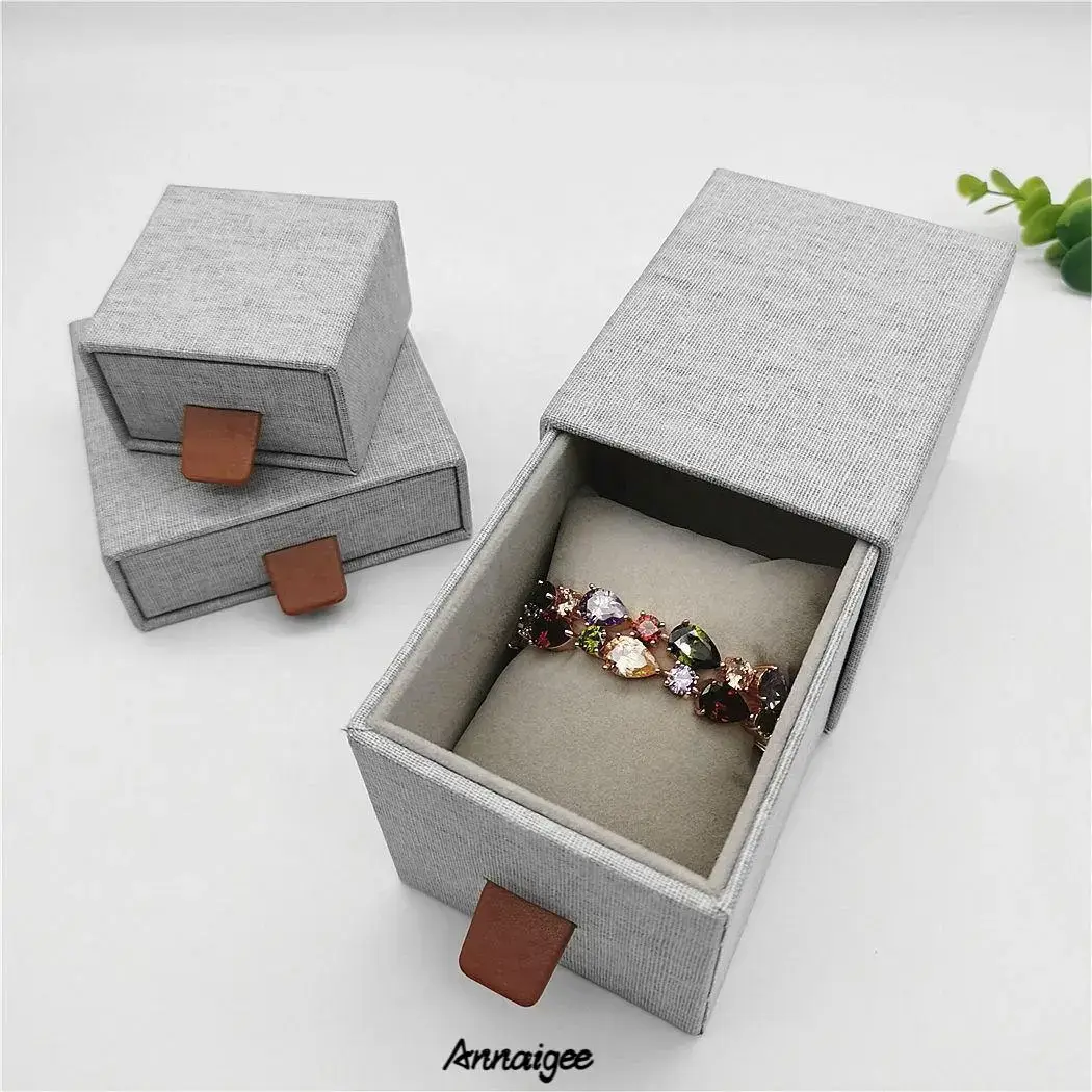 Linen fabric sliding drawer jewelry box with compartmented interior for earrings, rings, bracelets, and necklaces
