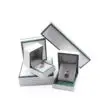 Custom white paperboard jewelry box with black border accent and protective foam insert
